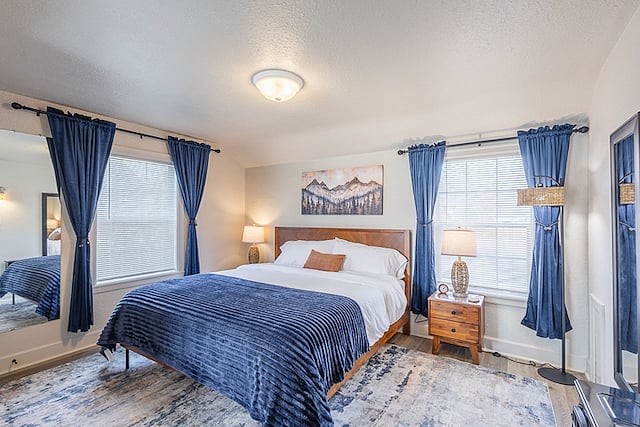 Primary Bedroom (upstairs): King bed with hybrid memory foam mattress, fireplace-style space heater, tower fan, swivel smart TV & Blu-ray, comfy chair, workspace, lots of natural light, sit-down arcade game, 2 closets, and mountain-themed decor.