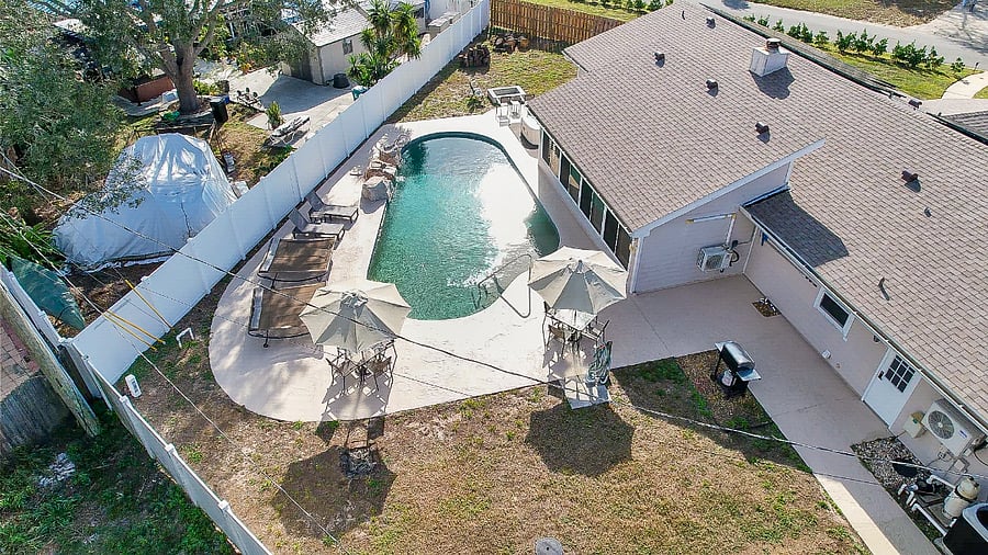 Aerial facing south. Backyard with pool, fire pit, and hot tub.