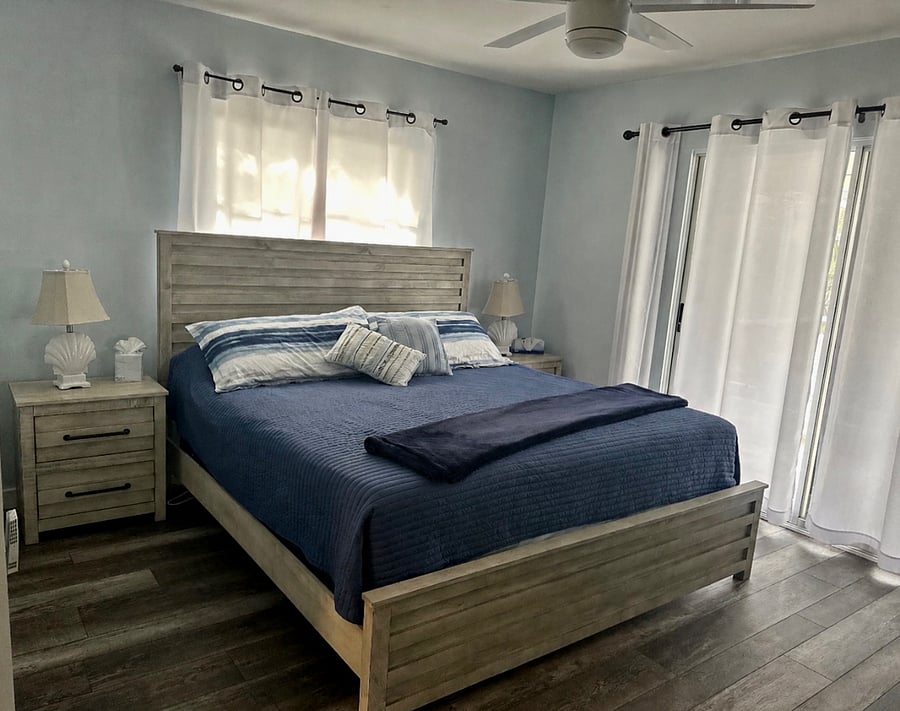 Primary bedroom with king size bed. Slider door out to patio and pool. 
