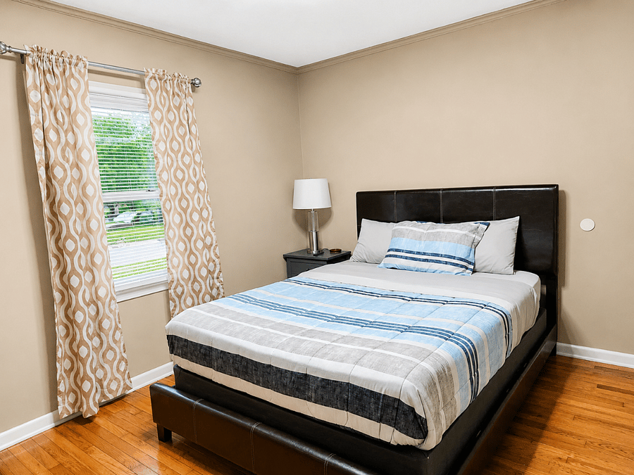 Comfortable bedroom with plush bed and hardwood floors