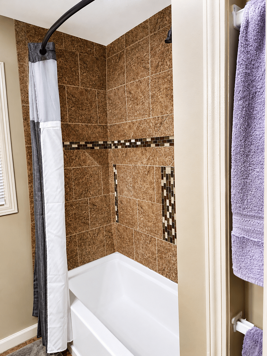 Updated bathroom featuring custom tile work and full bathtub