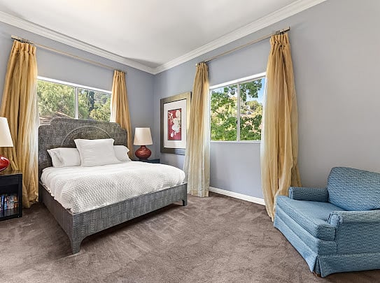 Primary suite with queen bed, canyon-facing windows, and en-suite bathroom access.