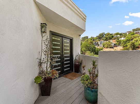 Private entry deck with mature landscaping, succulents, and canyon hillside backdrop.