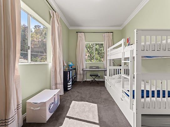 Second bedroom with twin bunk plus trundle (sleeps 3) and a desk by the canyon-facing window.