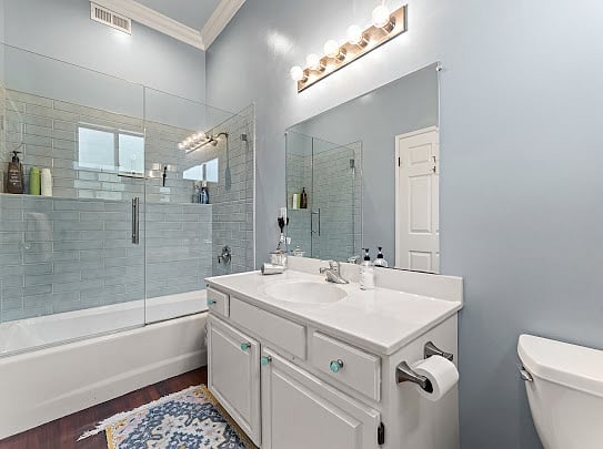 Full bathroom with walk-in shower-tub combo, white subway tile, and upgraded vanity.