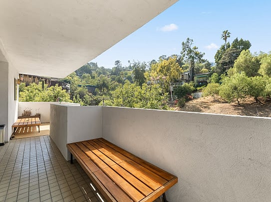 Upper balcony off the office with teak bench seating and panoramic canyon and hillside views.