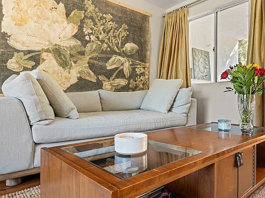 Living room detail with sectional seating, curated art, and a wood coffee table on a natural fiber rug.