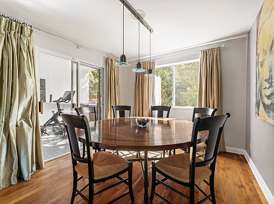 Dining for six with sliding doors to the covered patio and Peloton beyond.