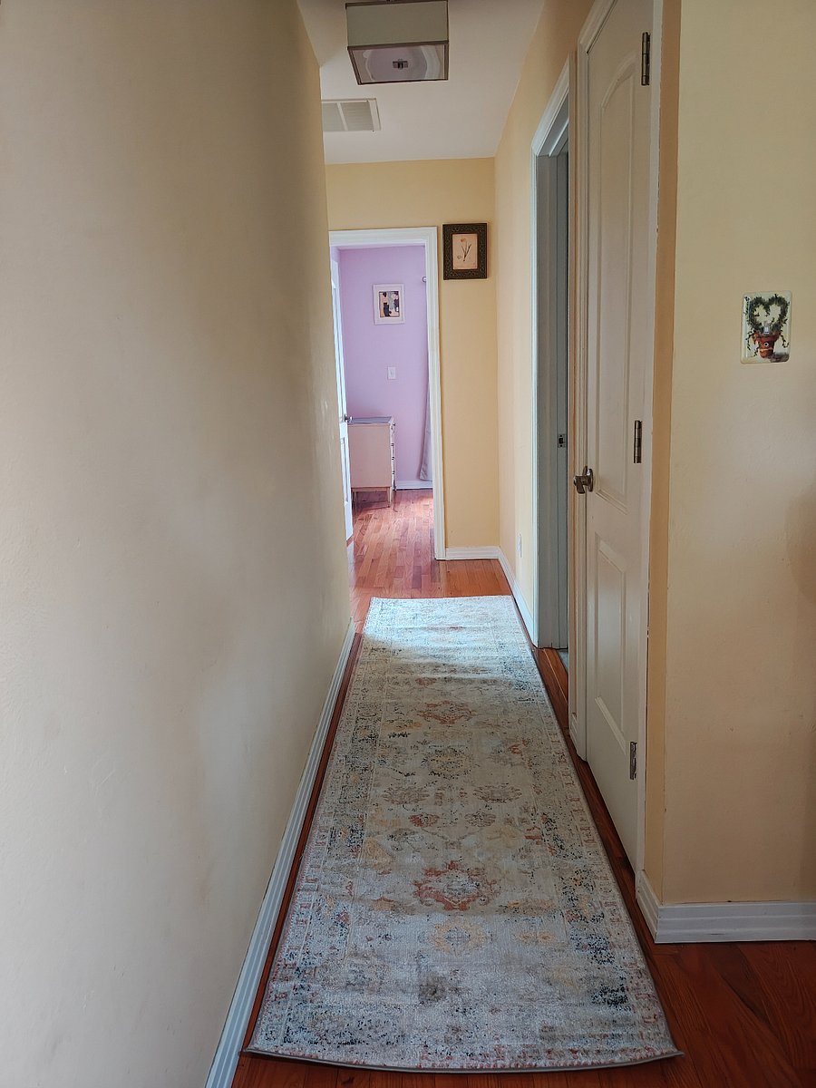 Hallway to bedroom, sunroom, deck access. Private bath on right.