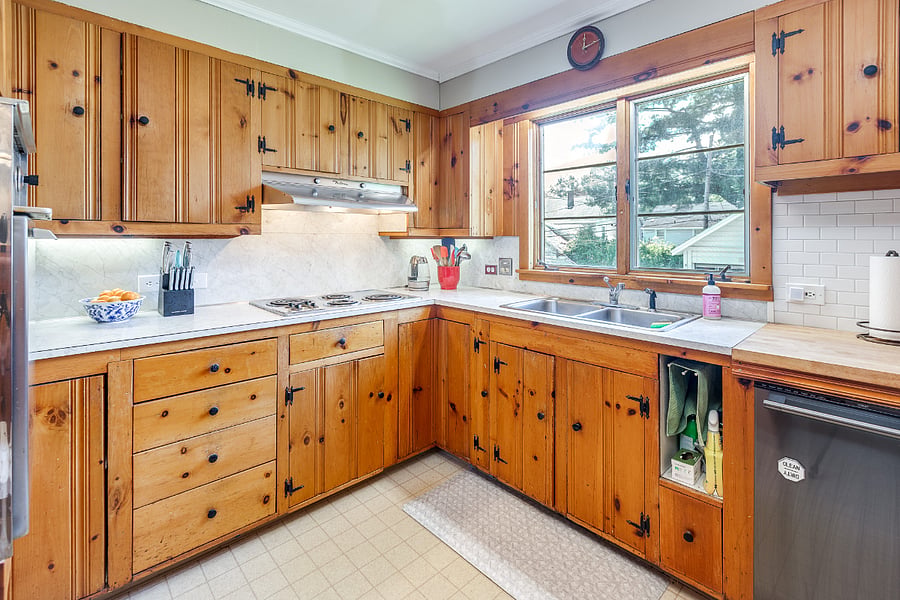 Kitchen with retro electric stove, range hood, and oven; dishwasher; double sink; microwave; and refrigerator 