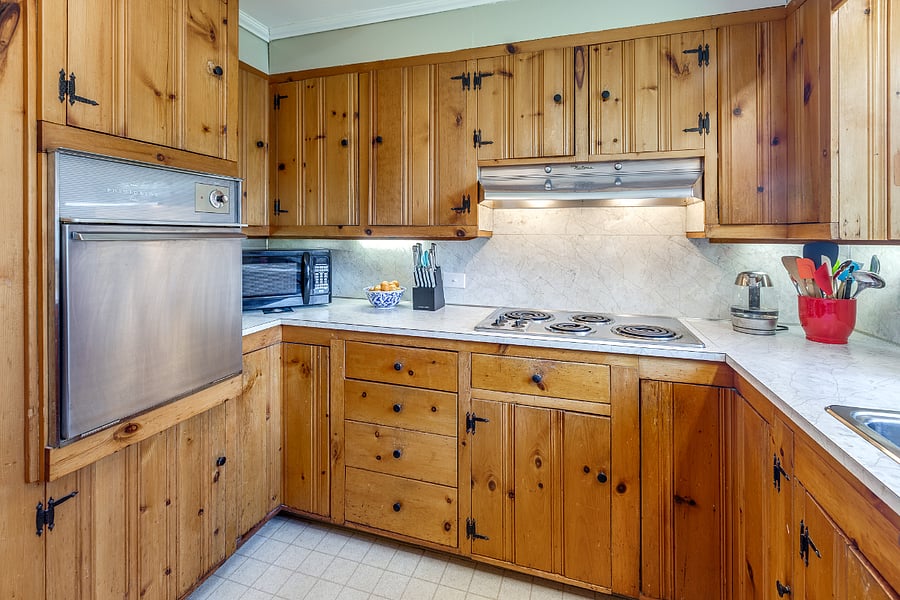 Kitchen with retro electric stove, range hood, and oven; dishwasher; double sink; microwave; and refrigerator 
