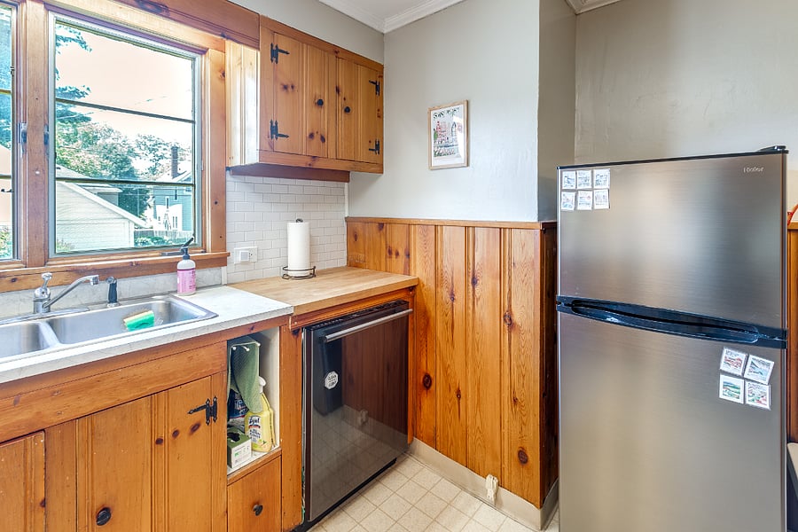 Kitchen with retro electric stove, range hood, and oven; dishwasher; double sink; microwave; and refrigerator 