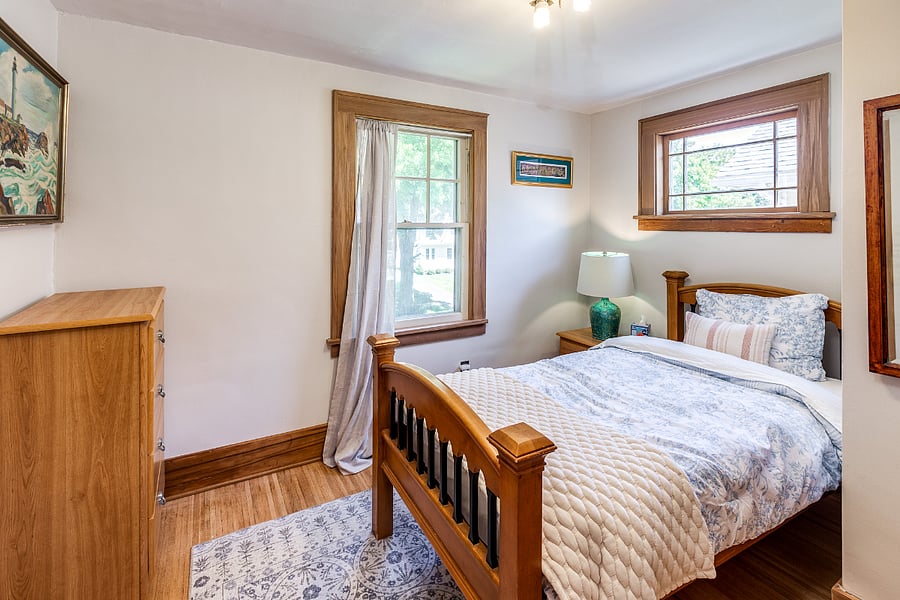 Bedroom with twin bed, mirror, nightstand, closet, and dresser
