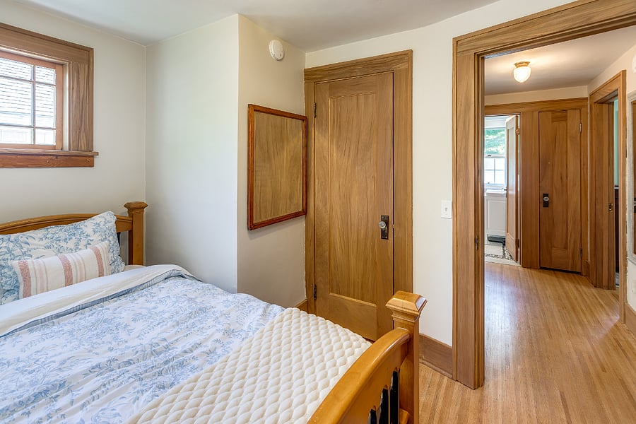 Bedroom with twin bed, mirror, nightstand, closet, and dresser