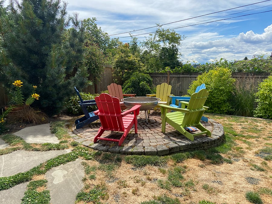 Backyard (shared space with owners and two friendly dogs) that includes a fire pit and Adirondack colorful chairs and during summer months, a hammock. 