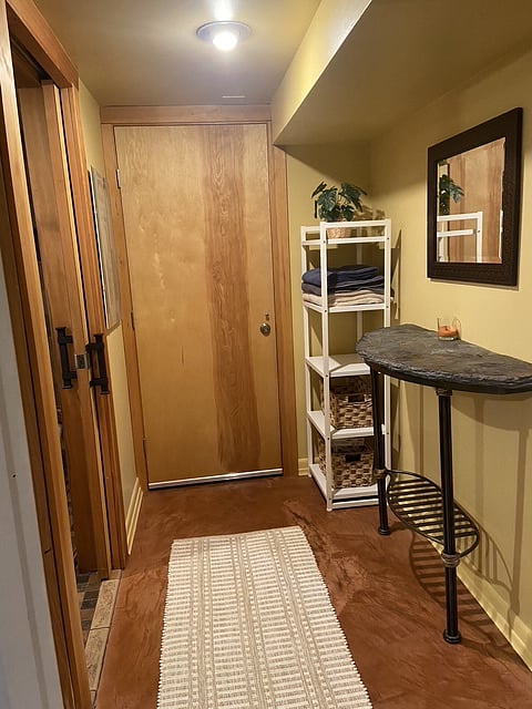 Bathroom hallway with display and storage cabinet, mirror and granite table top (nice place to display jewelry or special photos). 