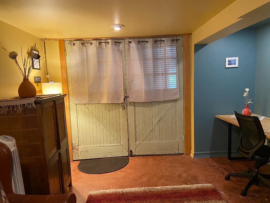 View of apartment entry doors (desk/workspace to the right and a storage cabinet for office supplies or other items)