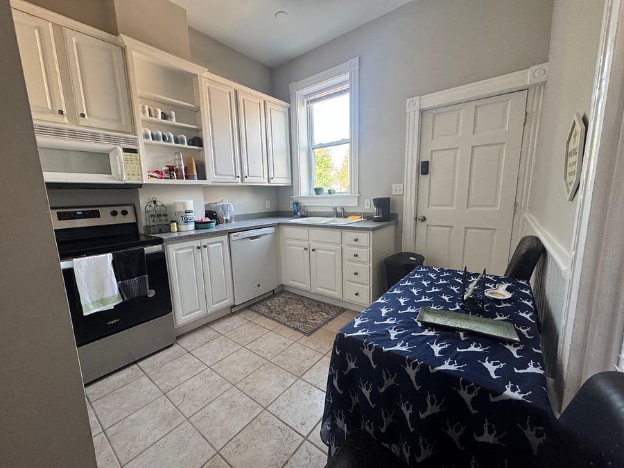 Fully equipped kitchen showing dishwasher, lots of cabinets and shelves and cozy dining nook
