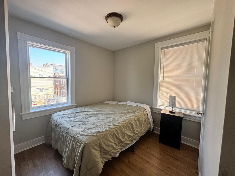 This cozy bedroom overlooking the backyard is bright and cheerful. A full closet and shelves add a nice completing touch. 