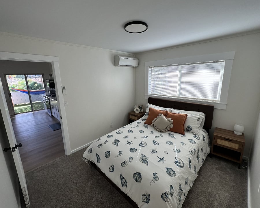 Bedroom #1 - queen size bed, has an AC split unit and carpet.
4 storage drawers underneath bed and an armoire with hangers and shelves.