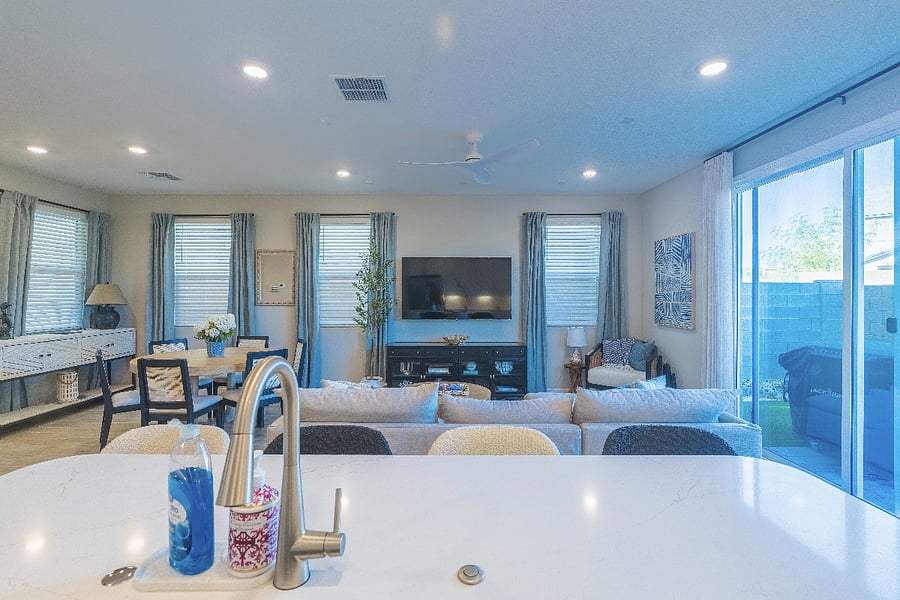 Bright and modern living space featuring an open-concept kitchen, cozy lounge area, stylish decor, and abundant natural light