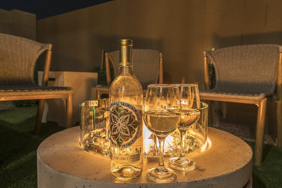 Romantic fire pit setting with wine and glowing ambiance.