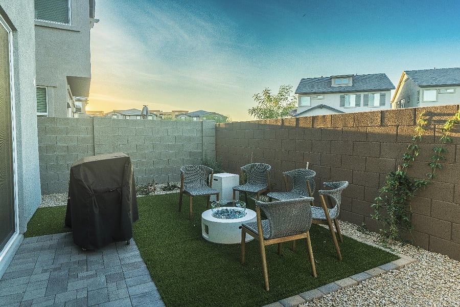 Beautiful sunset view from a private backyard with fire pit seating and outdoor grillperfect for evening relaxation.