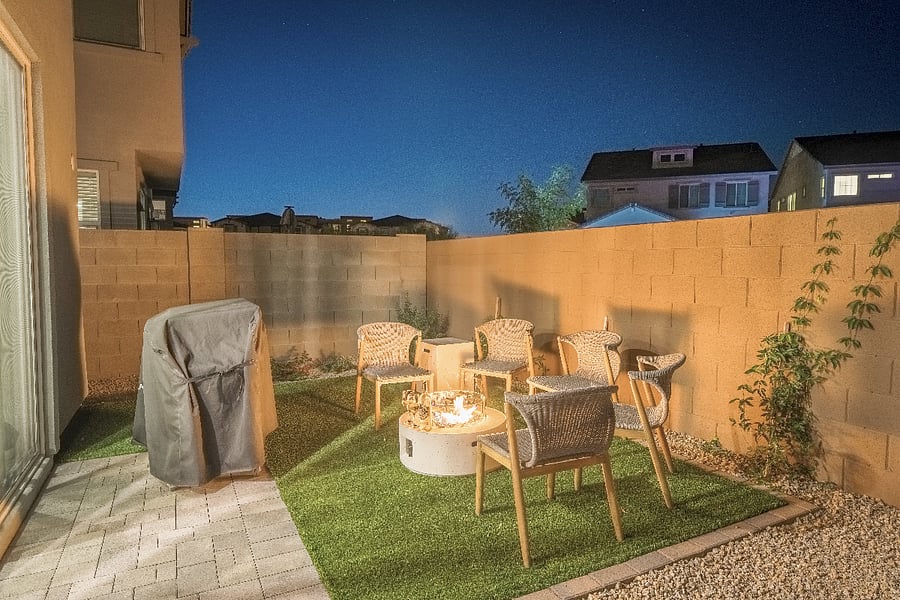 Inviting nighttime fire pit area with warm lighting and modern seatingan ideal spot for guests to unwind under the Arizona sky.
