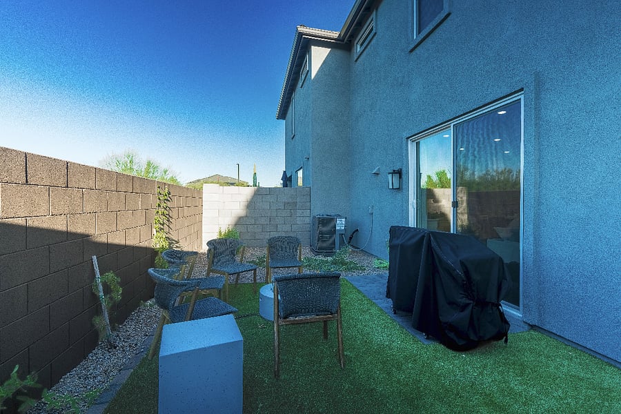 Low-maintenance backyard featuring artificial turf, fire pit lounge area, and privacy walls.