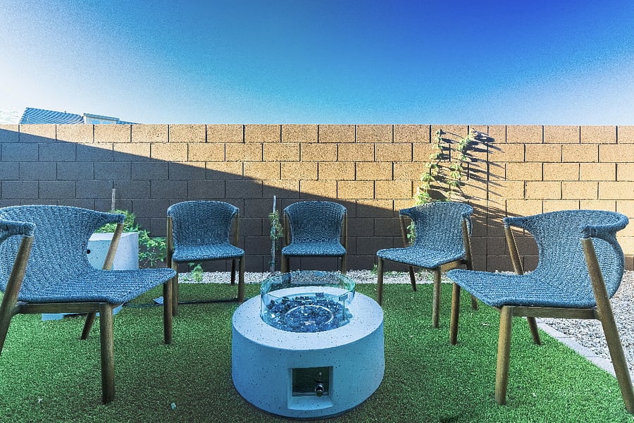 Cozy backyard with modern outdoor chairs and a gas fire pit on turfperfect for relaxing evenings.