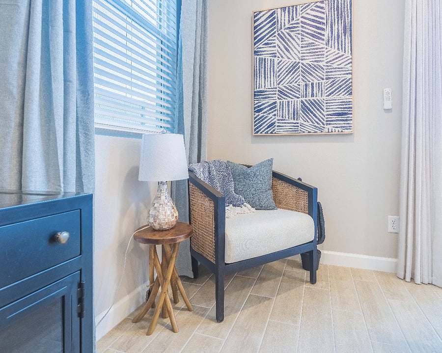Cozy reading nook with stylish accent chair, textured wall art, and natural light.