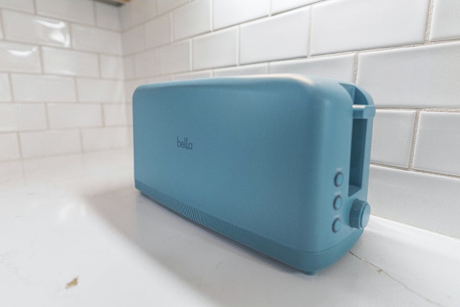 Modern turquoise toaster on white quartz countertops brings a colorful accent to this clean, modern kitchen.