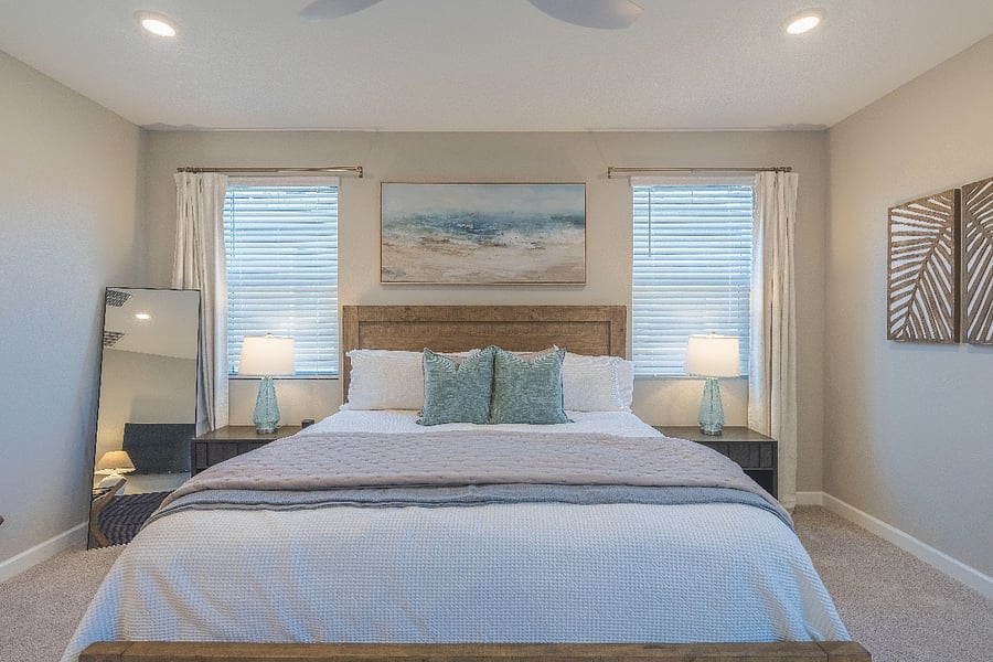 Clean and elegant master bedroom with matching lamps, soft textiles, and calming decor.