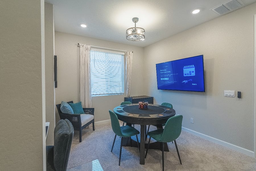 Cozy upstairs lounge featuring a poker/game table, comfy seating, and a big-screen TV an ideal hangout spot after a day of exploring.