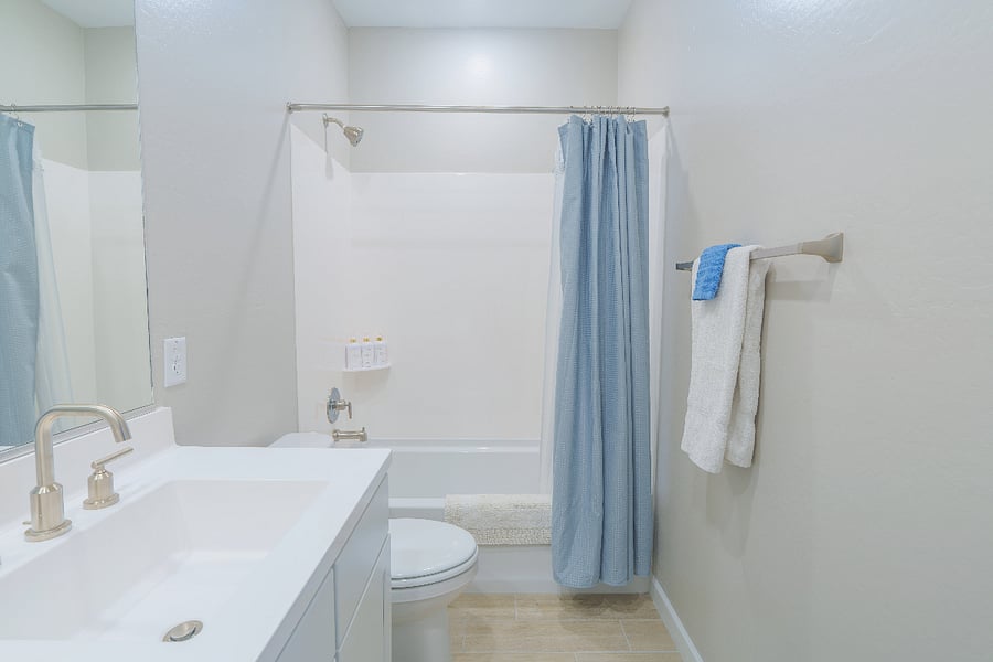 Bright and spotless full bathroom featuring a refreshing shower/tub combo, soft towels, and everything you need for a comfortable stay.