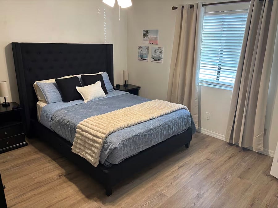 Bedroom 2 with queen bed, closet, dressers and smart TV.