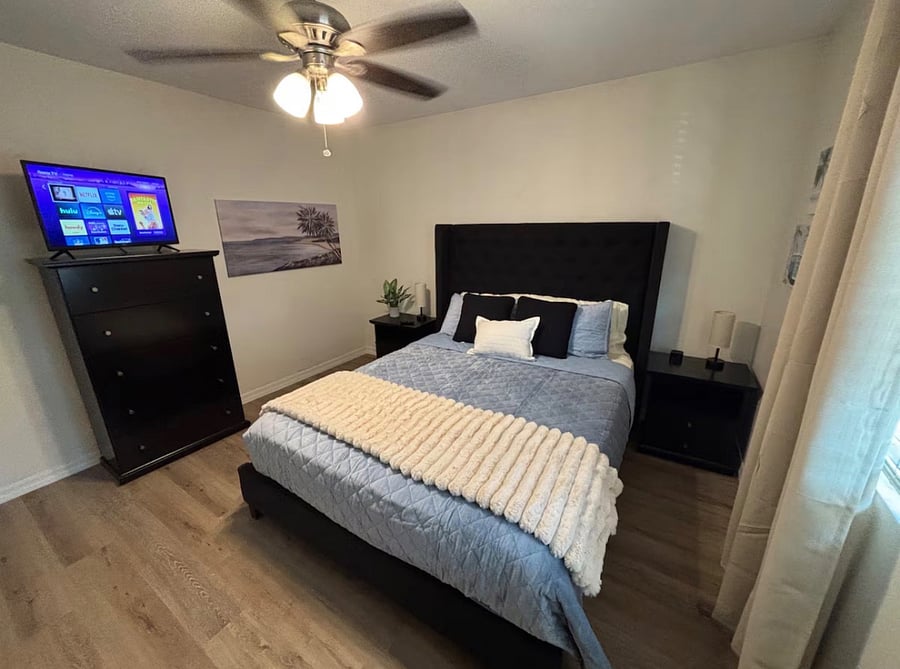 Bedroom 2 with queen bed, closet, dressers and smart TV.