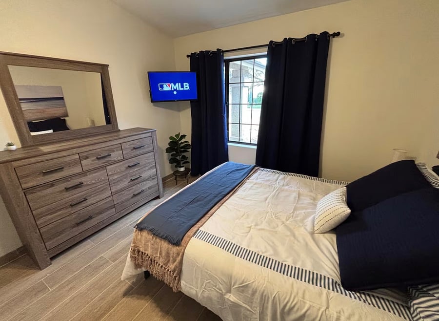 Bedroom 3 with queen bed, closet, dressers and smart TV.