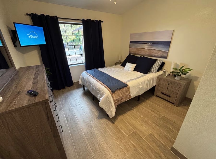 Bedroom 3 with queen bed, closet, dressers and smart TV.
