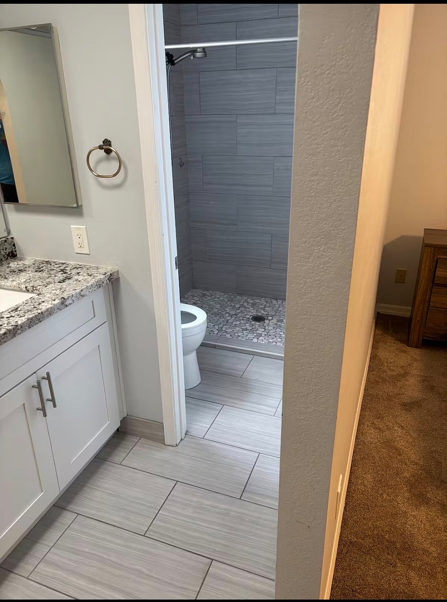 Primary bathroom with dual vanity, storage, and walk-in shower.