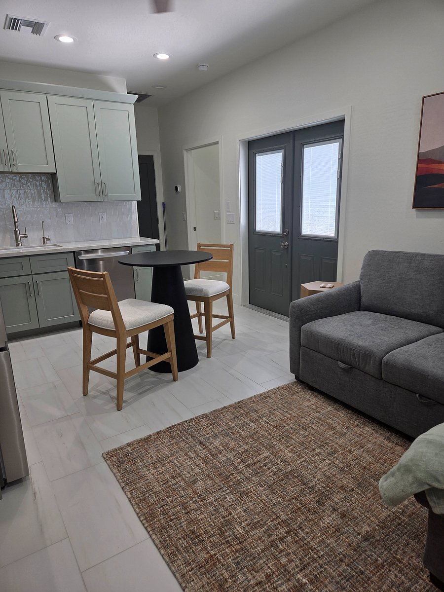 Open-concept living space with dedicated entry, smart TV, and modern furnishings.
