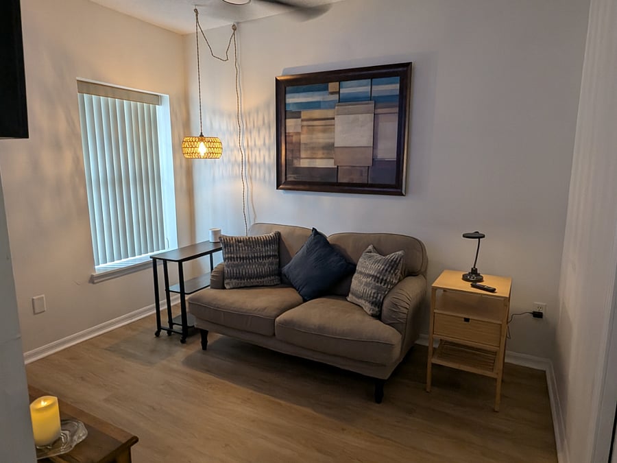 Living room with couch, small extendable laptop table and table lamp with USB charger