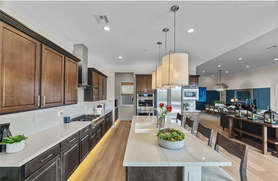 Gourmet kitchen with large island & seating, professional gas range, large refrigerator, ample shelf space (with hidden walk-in pantry), microwave, and ovens avail.
