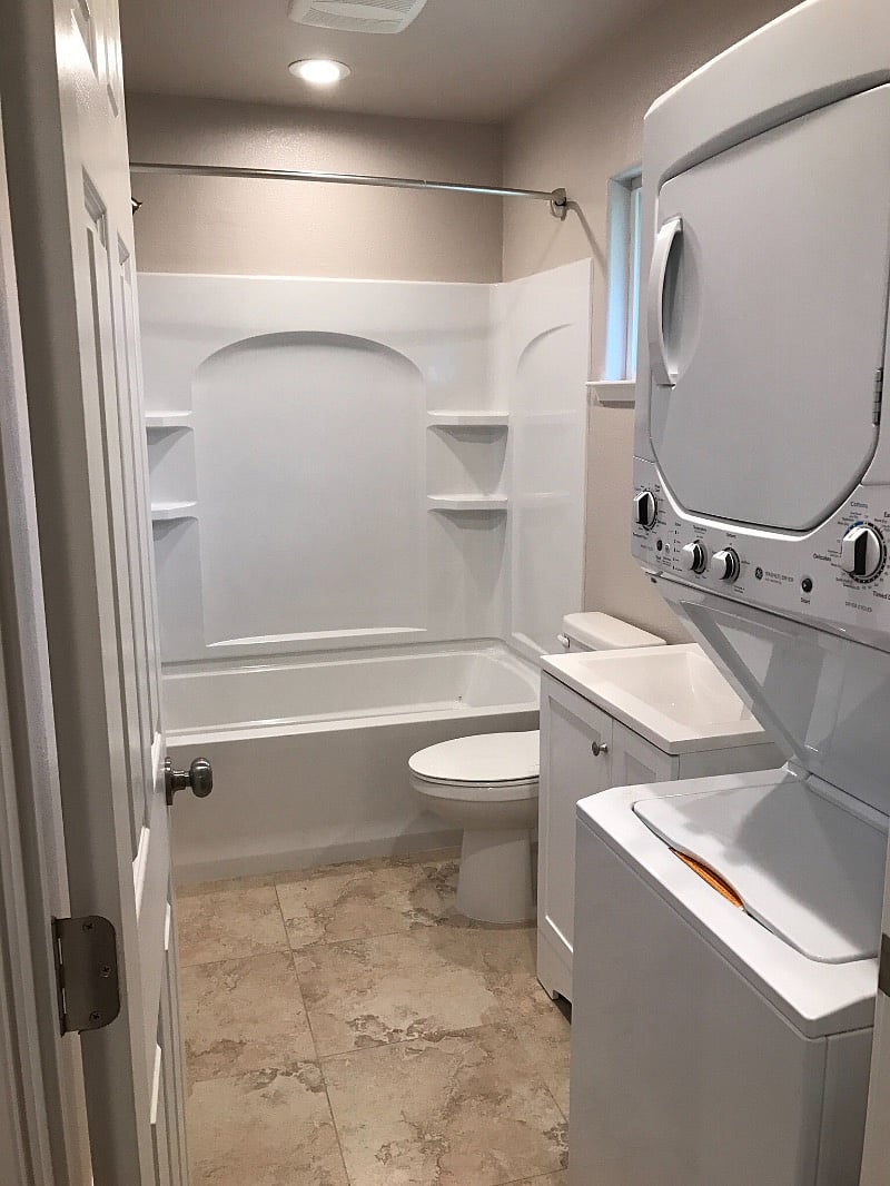 Shower w/tub and washer/dryer in bath.