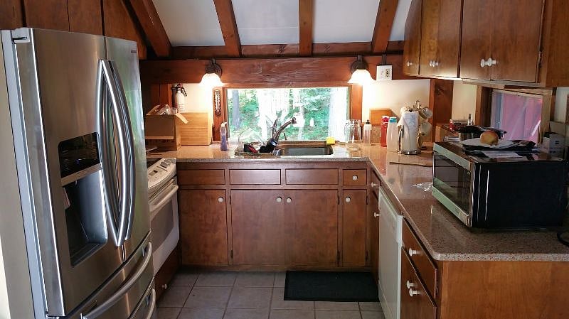 Fully equipped kitchen with microwave, dishwasher, range, french-door refrigerator with ice and filtered water, and other small appliances.